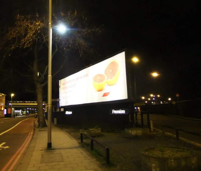 the billboard has fruit on it at night