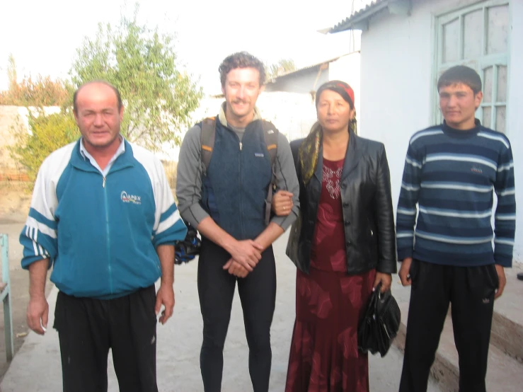 a group of four people standing in front of a white building