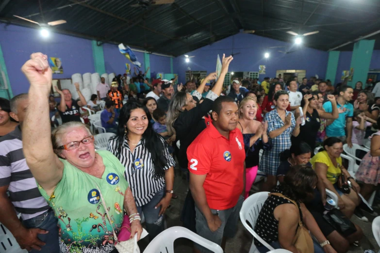 a group of people in a room with one holding his hands up