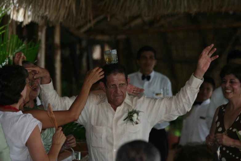 a man in a white suit standing next to other people