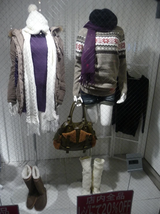 three pairs of hats and scarves hanging in a shop window