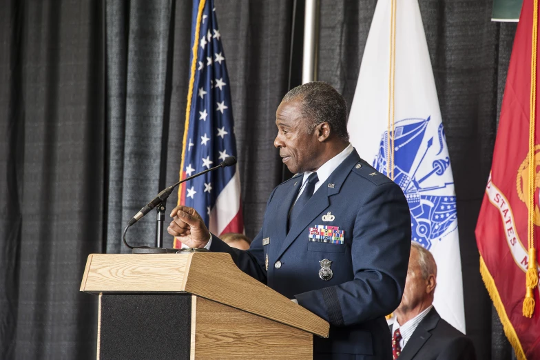 the man wearing an army uniform standing at a podium speaking