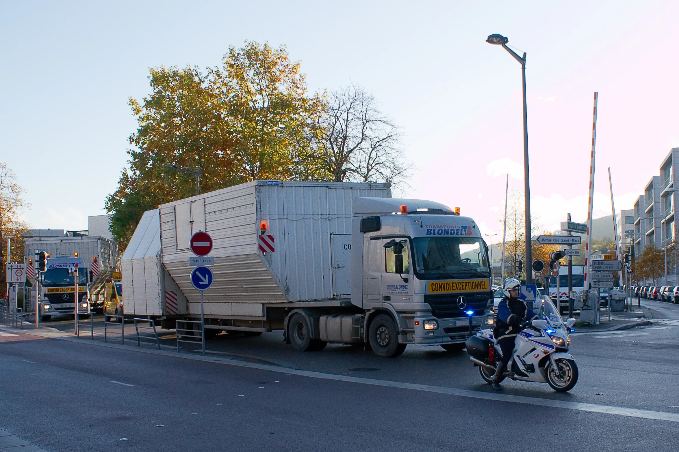 a person on a motorcycle rides past a truck