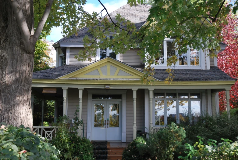 a house with a black roof and white trim and trees