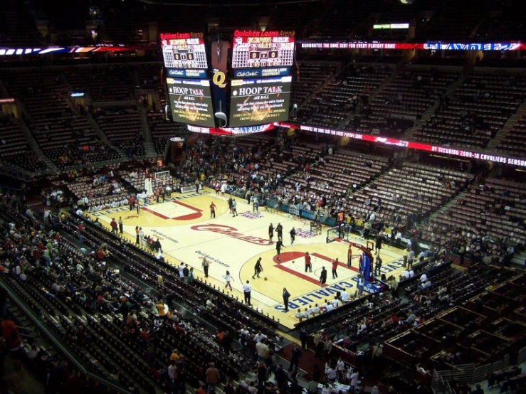 a large sports court has fans standing around it