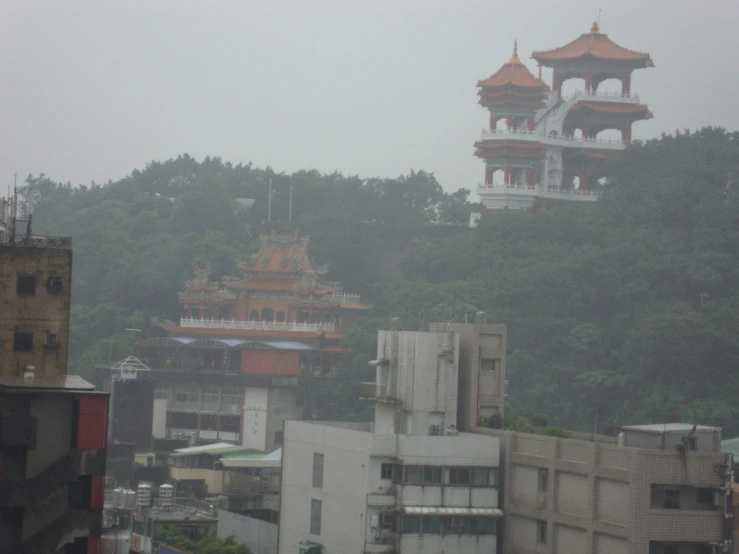 buildings near a hill with a pagoda on top