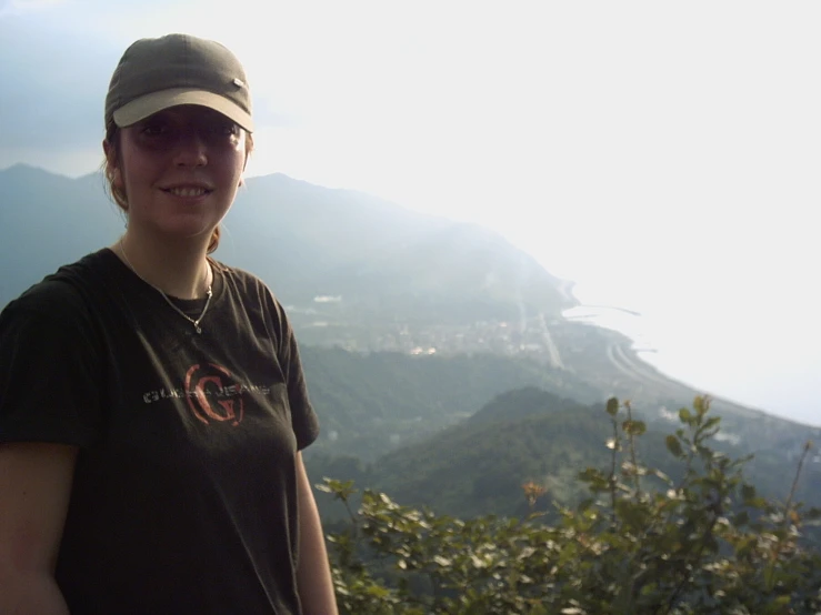 woman in hat and sunglasses with mountains in the background