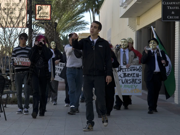 many people holding signs and protesting on a city street