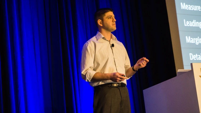 the man is making a presentation at a conference