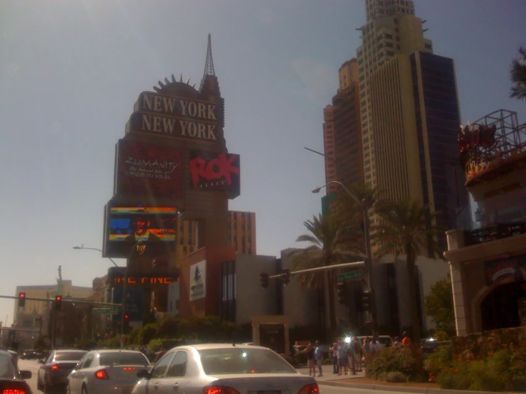 a group of cars in traffic driving past tall buildings