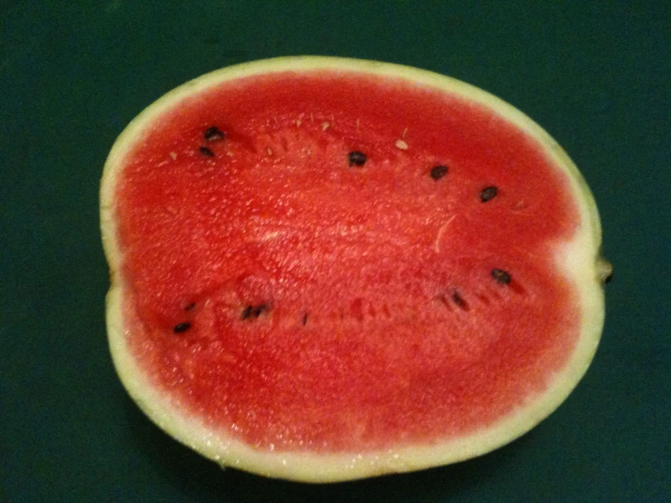 a watermelon cut in half with a few black pieces