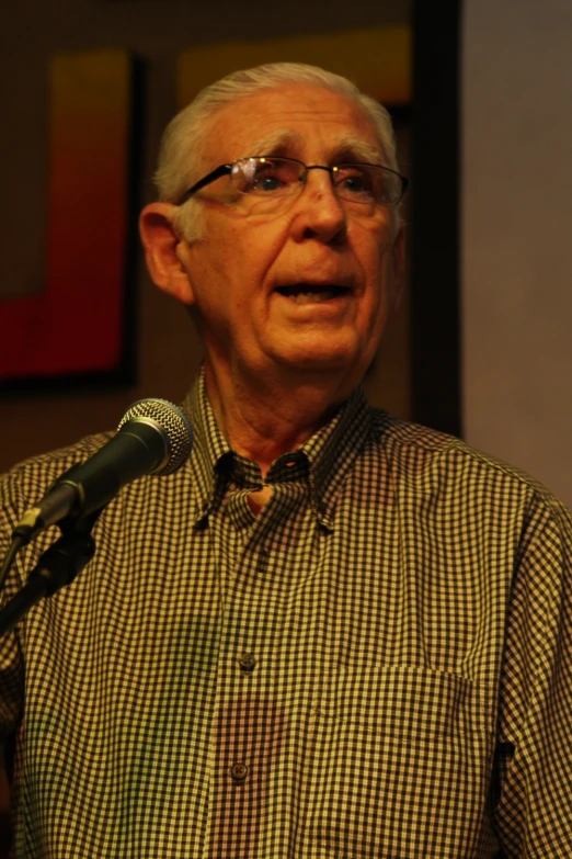a man holding a microphone and looking to his left