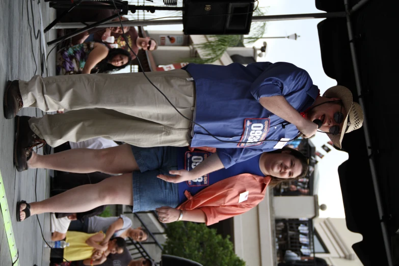 a man with a microphone speaks into a crowd