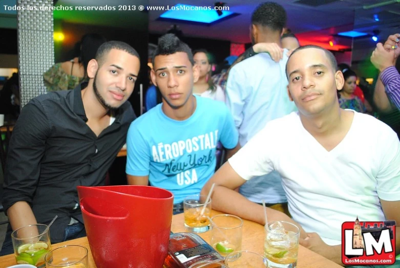 a group of three men in a restaurant posing for a po