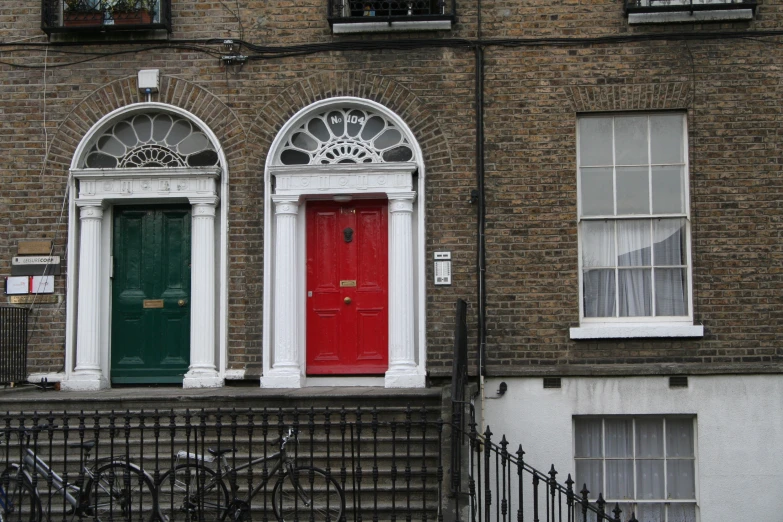 a red and green door on a two story building