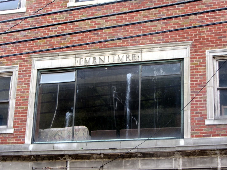 a brick building with a broken window and a sign