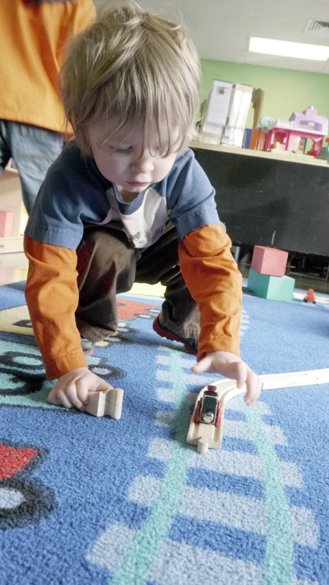 a young child playing with some legos on the floor