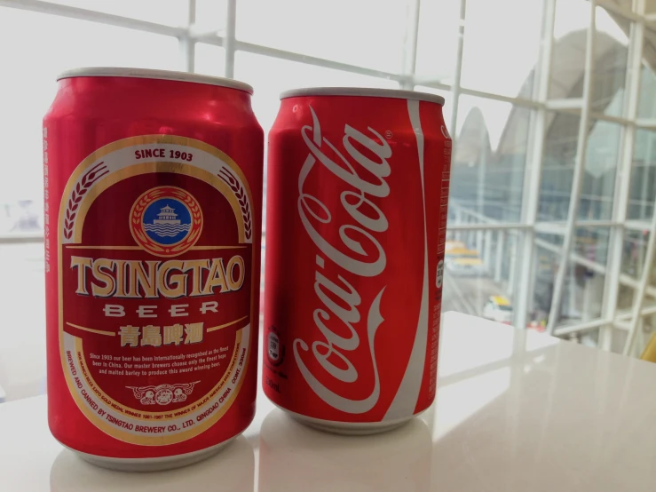 two canisters of coca - cola, one of which has a large amount of sugar