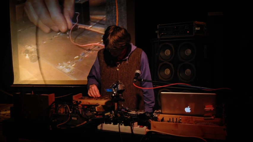 a woman in front of a projection screen with an apple computer