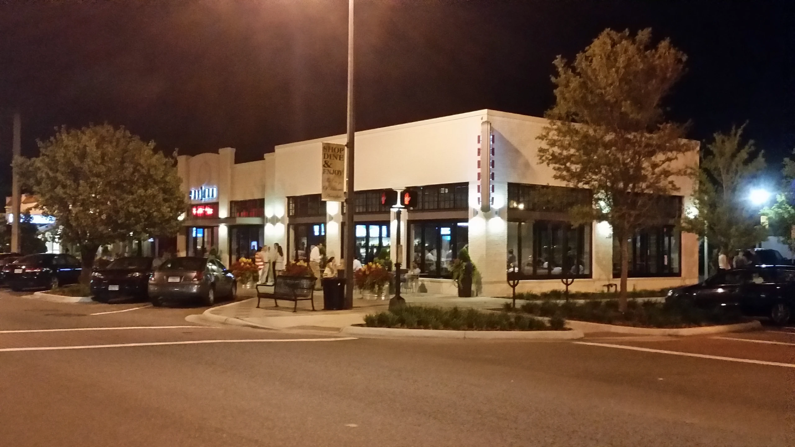 a shopping center at night with traffic lights