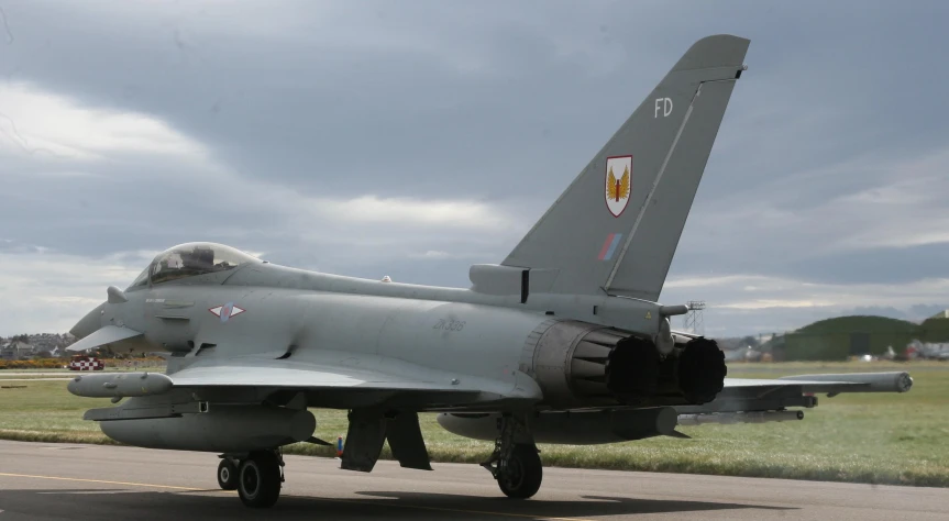 a fighter jet sitting on top of an airport tarmac