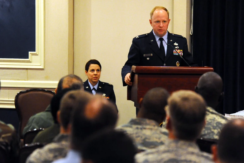 two soldiers standing behind a podium with their hands raised