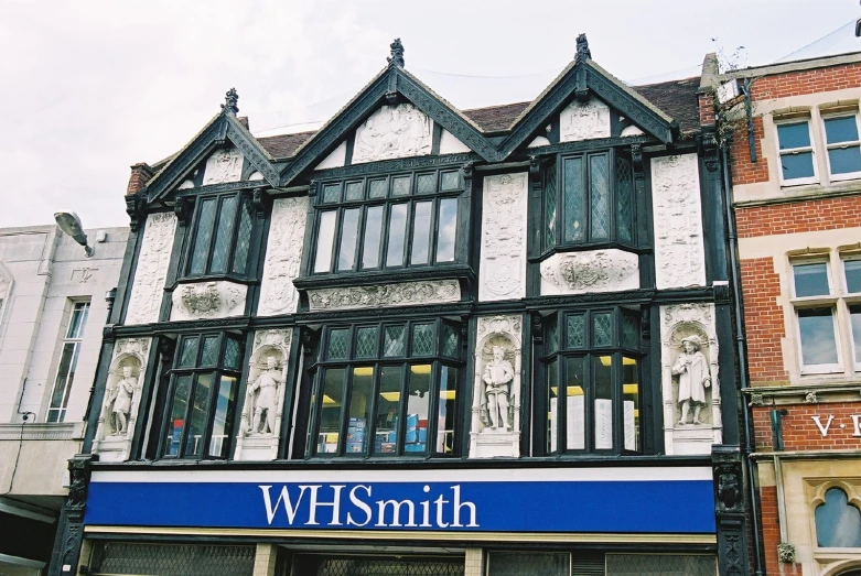 an old - fashioned building with a blue banner and name is painted white and black