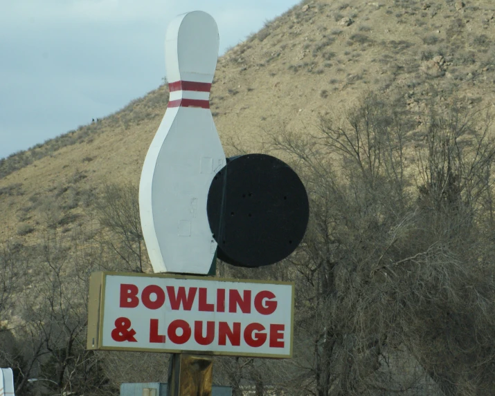 a bowling and lounge sign on a hill