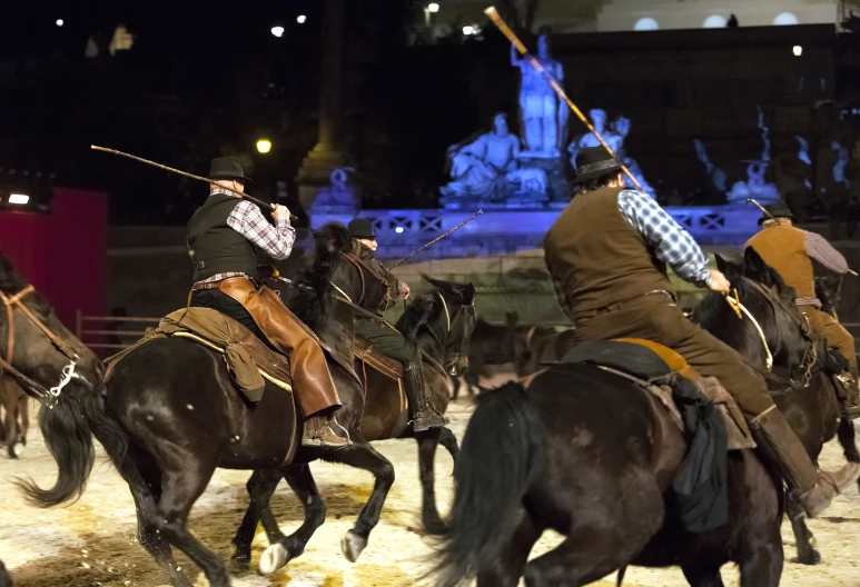 men in historical costumes riding on horses at night