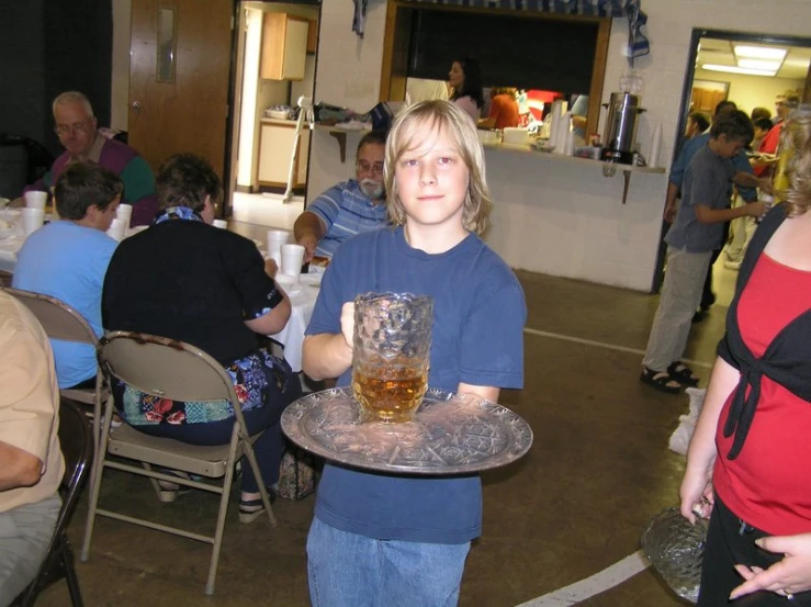 a  holding a glass of whiskey while sitting in a group