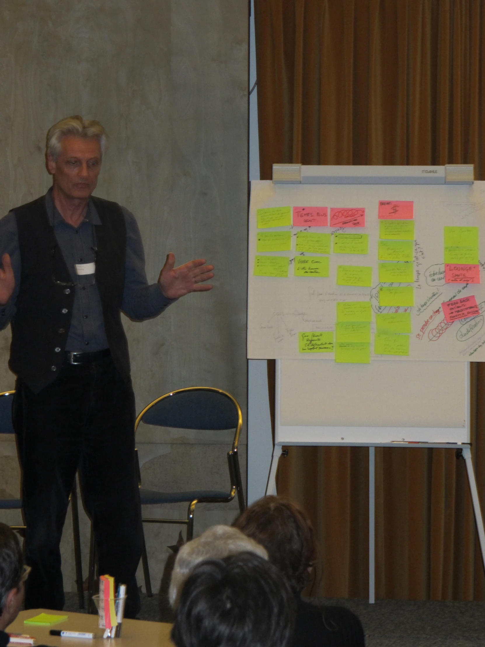 a man is in front of a whiteboard while giving a presentation