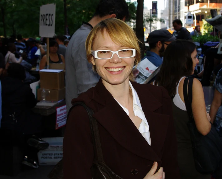 a woman with white glasses smiling for the camera