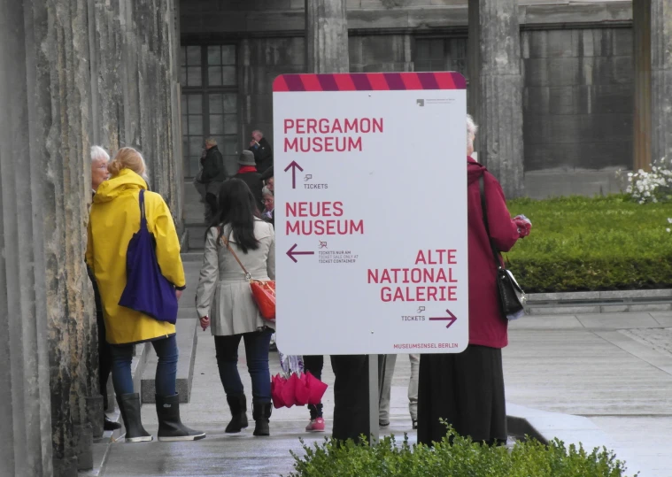 people looking at museum signs in the rain