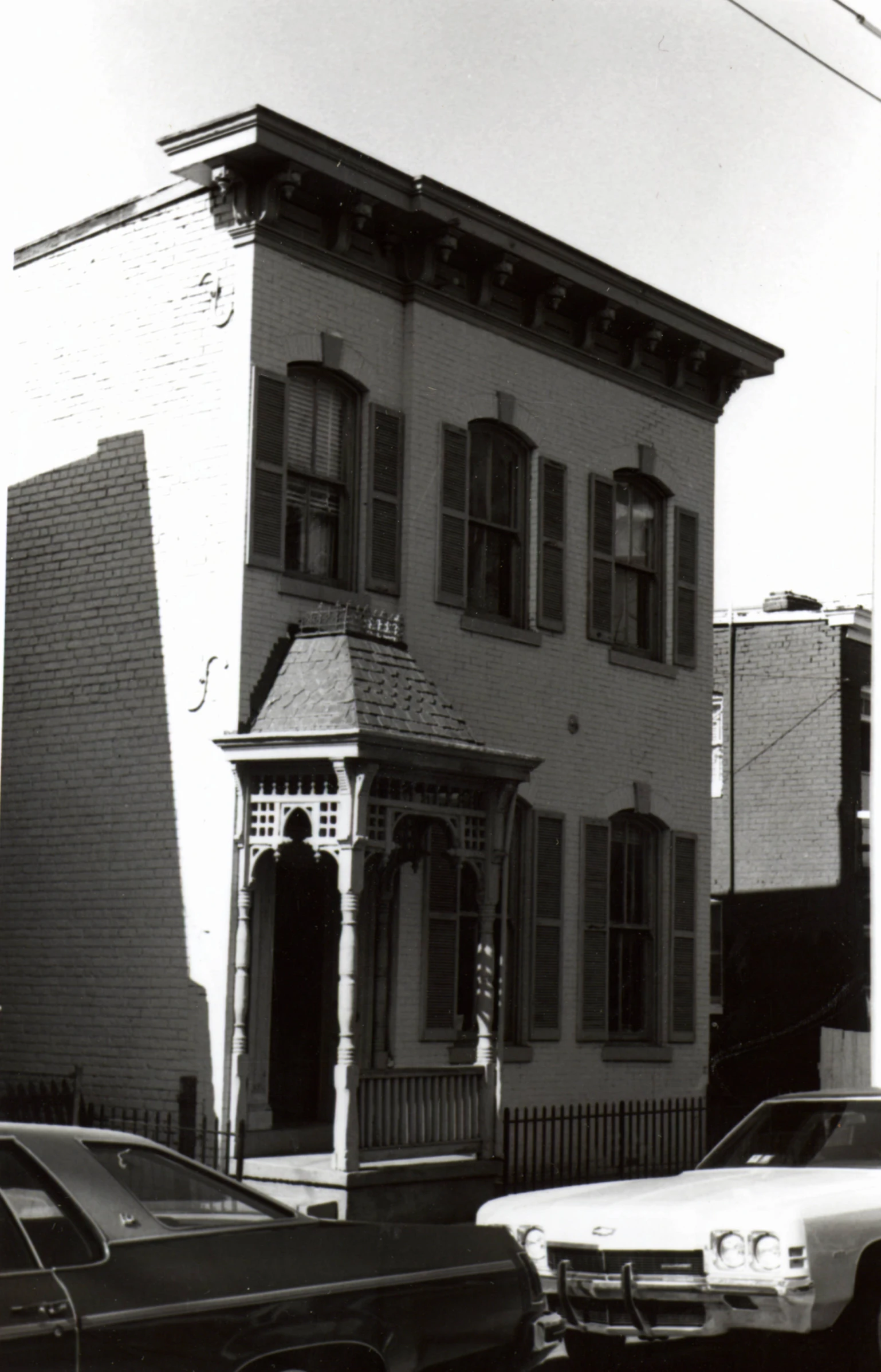 a car is parked in front of an old house