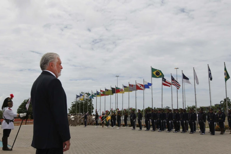 a man is standing in front of several flags