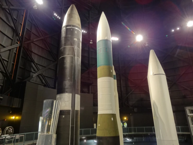 a group of large rockets sitting in a hangar