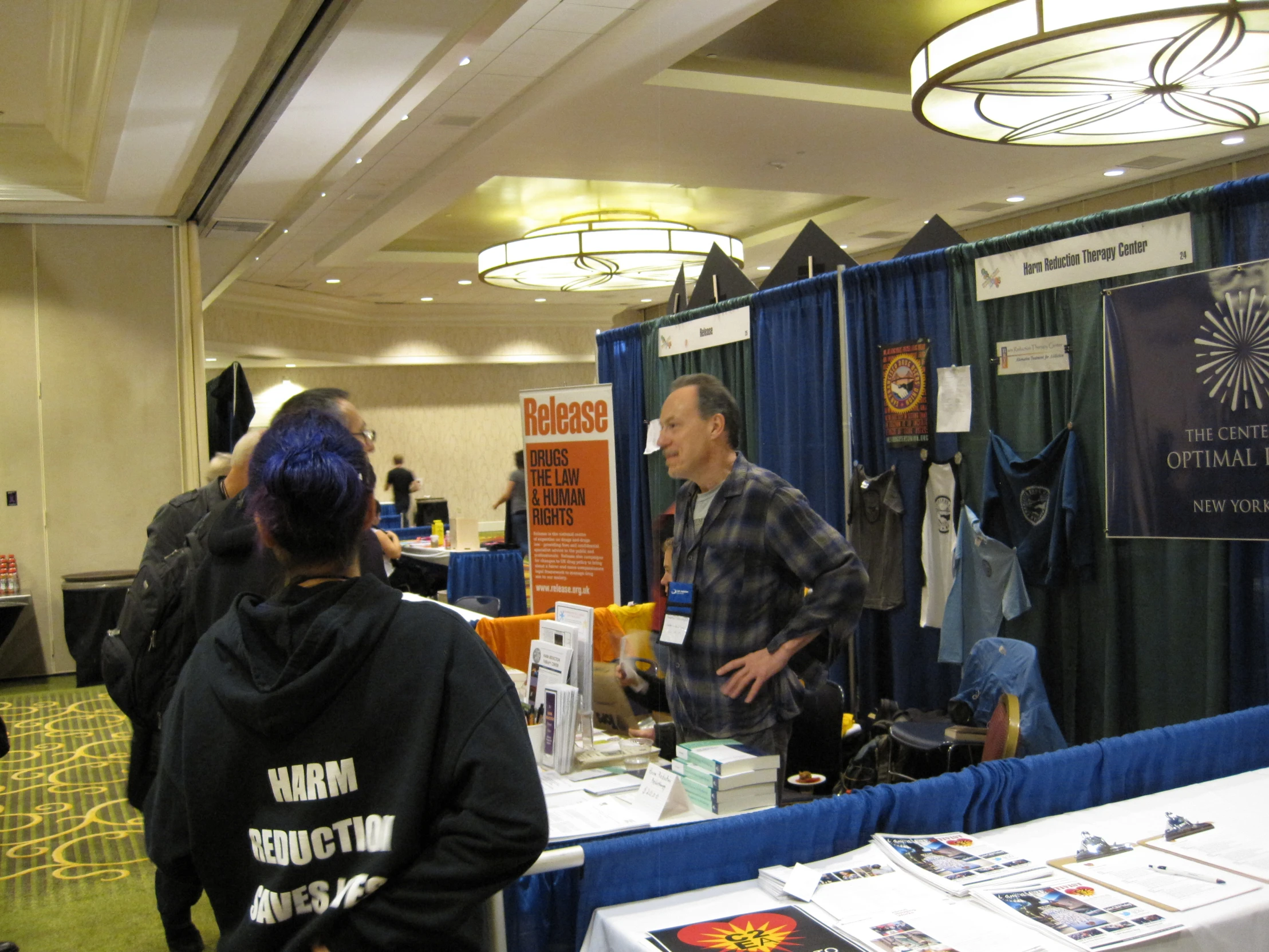 a man and woman standing at a booth on blue carpet