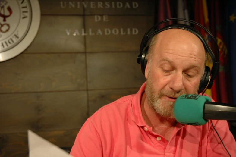 a man in pink shirt with headphones on