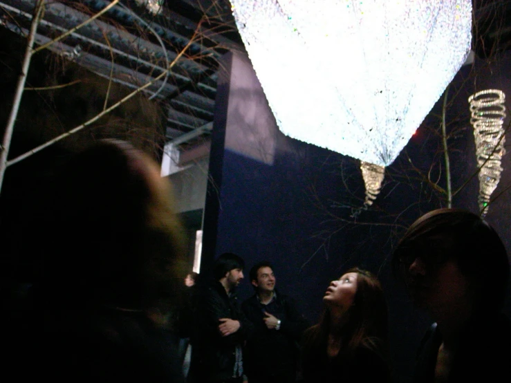 a crowd of people standing around in a dark room