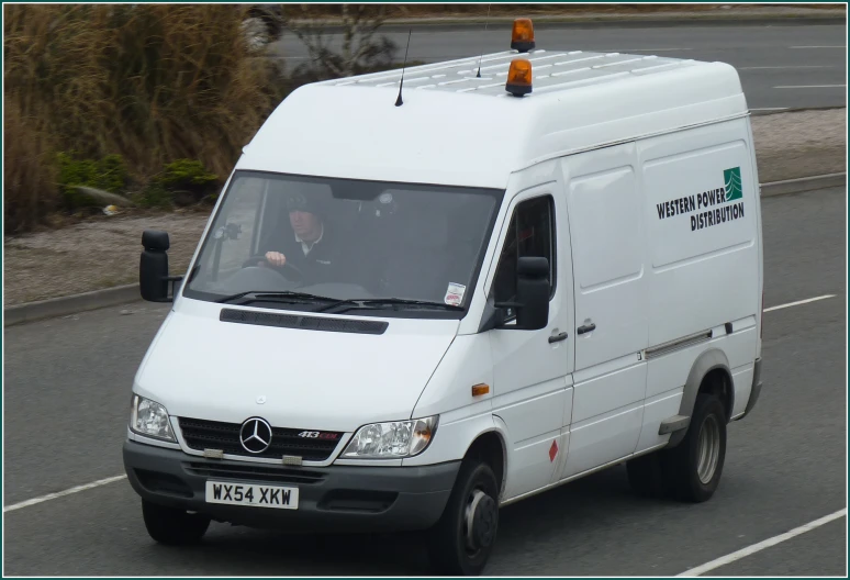 a man in a white mercedes - benz van on the road