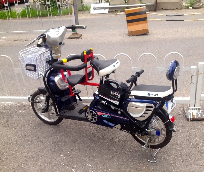 a moped is parked in front of a wire fence