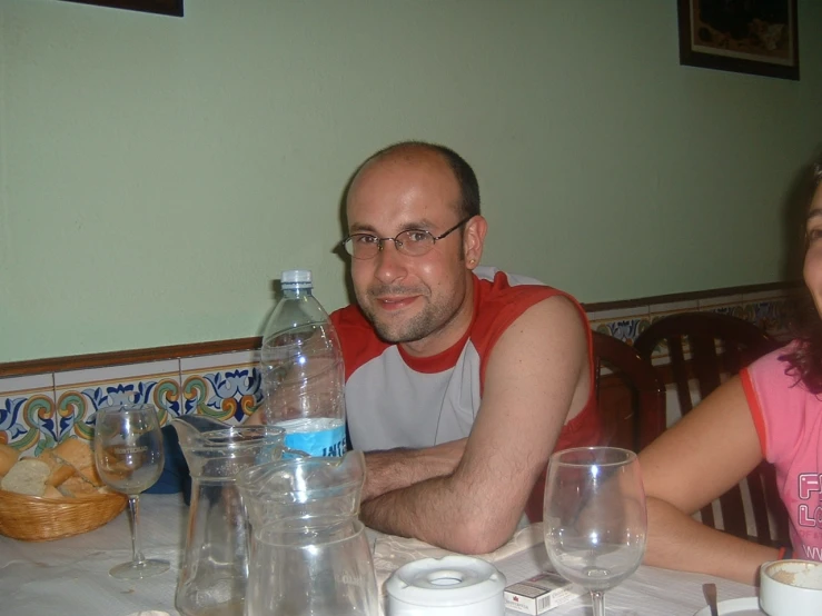 a man and woman sitting at a table smiling