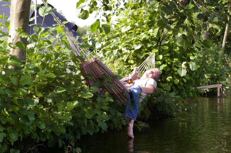 a woman lying in a hammock on the riverbank