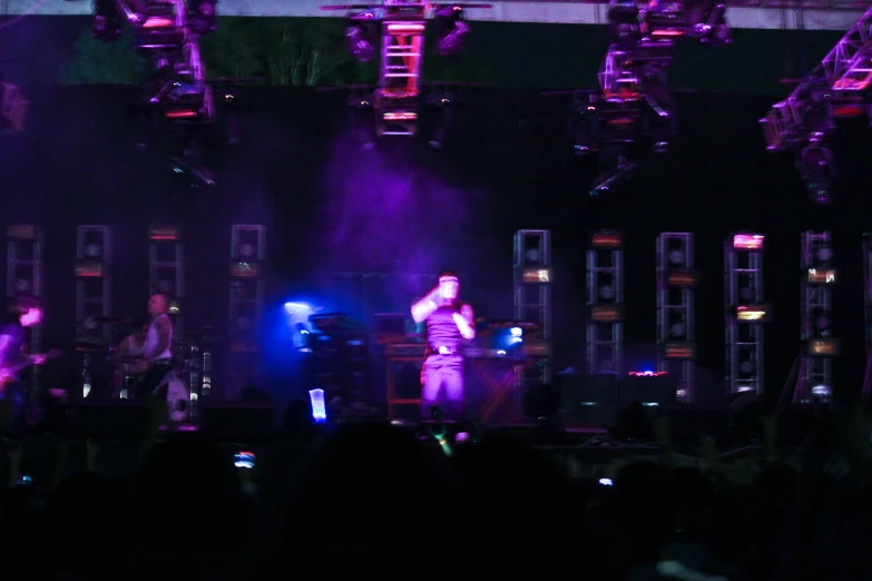 man standing on stage in front of an audience and lights in the background