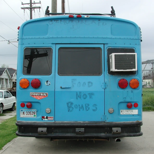 a blue bus sitting on the side of a street