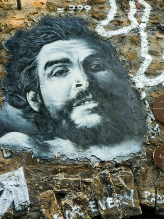 a mural of a man is painted on a stone wall