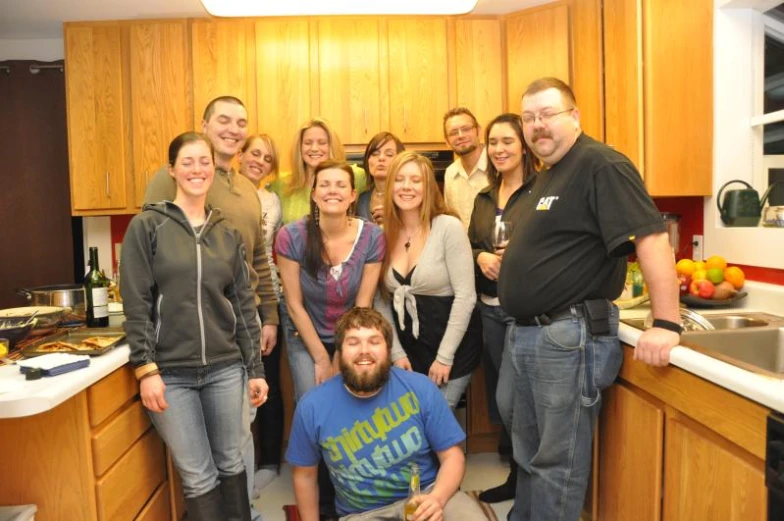 a group of people are posing together in a kitchen