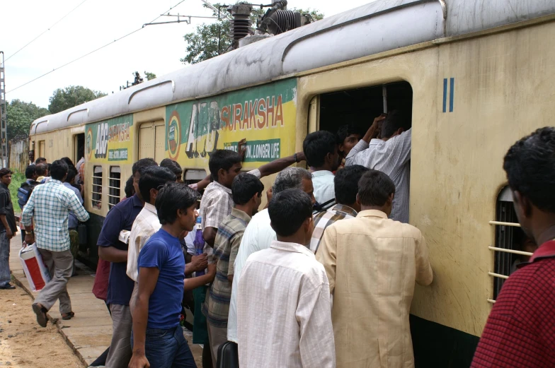 a crowd of people getting off and into a train