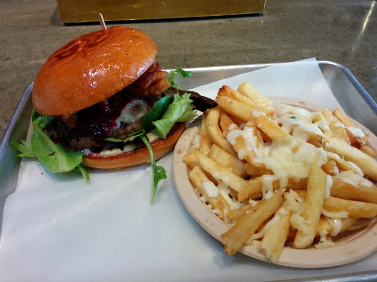 a large hamburger sitting on top of a white plate with french fries