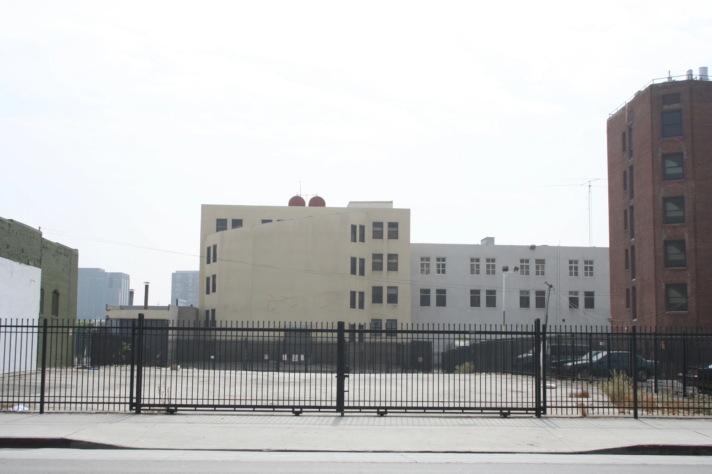 the gate is closed next to the building with tall windows